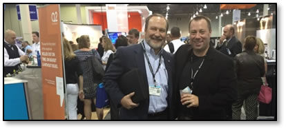 Trustmark’s Jonathan Rogers and Eric Weikart in the Expo Hall. Notice the backlog at Q2’s open bar in the background.